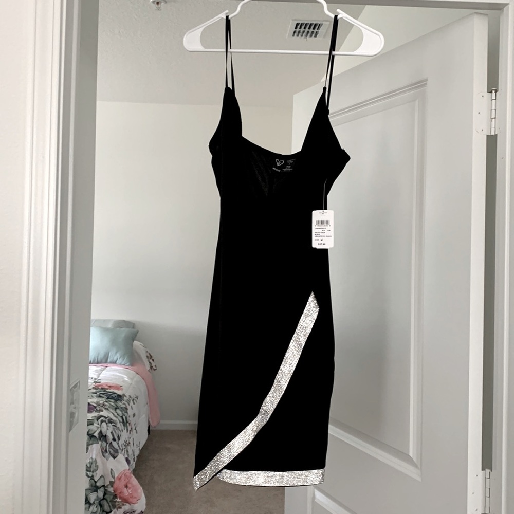 The holiday is coming pretty black dress with rhinestones on it .